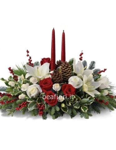 Composizione natalizia con fiori rossi e bianchi, candele e abete con altri devori.