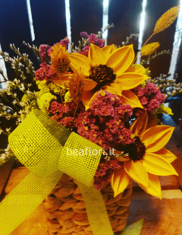 Composizione in cestino di vimini con fiore finto