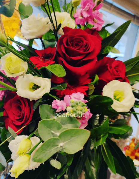 Bouquet con rose rosse e fiori di stagione